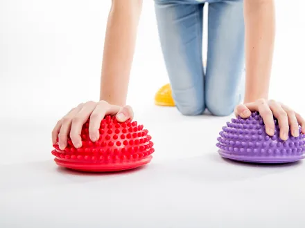 Ett barn som haller handerna pa tva piggkuddar